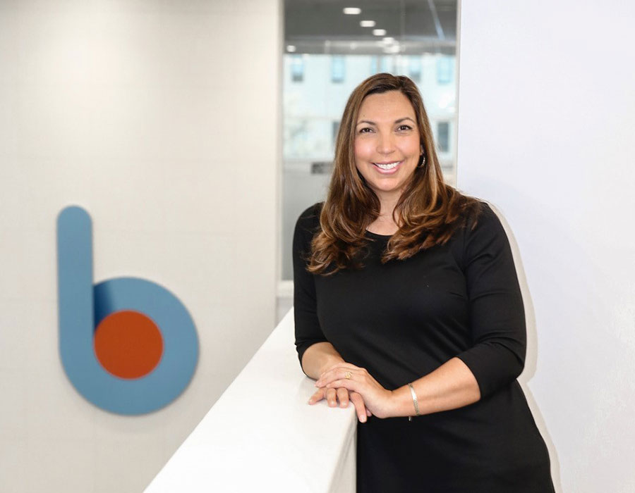 lady in black dress standing next to b1bank logo