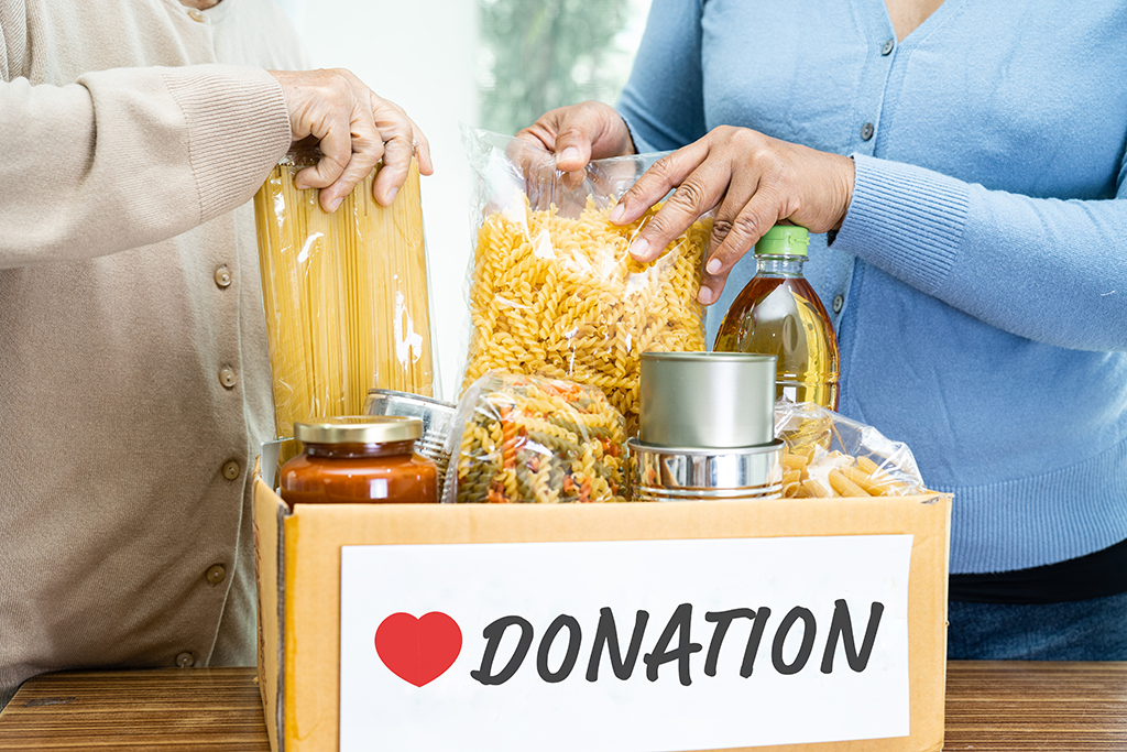 Volunteers putting dry food in donation box