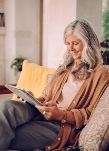 Woman sitting on a couch and working on a tablet