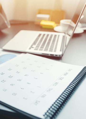 Calendar and laptop on a desk