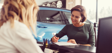 Woman taking notes in car dealership