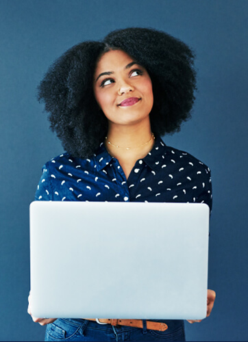 Woman smiling and looking to the right while holding a laptop