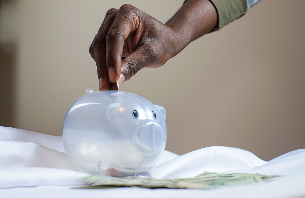 Man putting money in a piggy bank