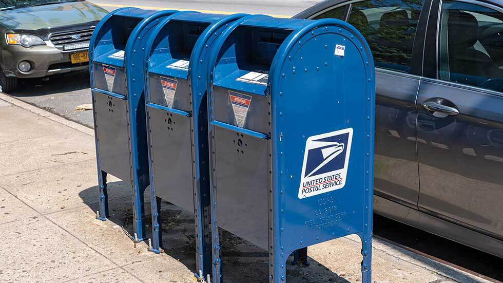 three blue USPS mailboxes
