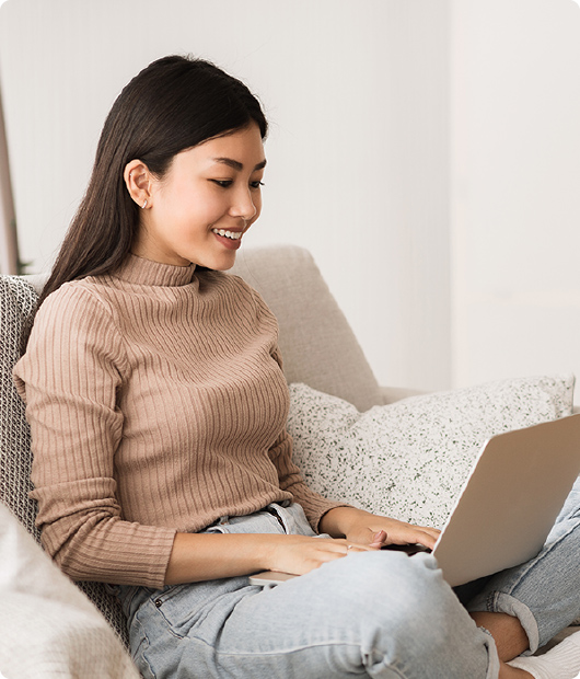 Woman looking at laptop on couch