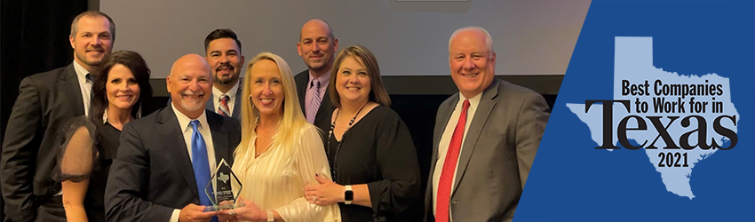 Employees pose with award on stage