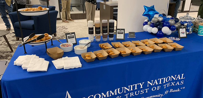 A table of donuts and toppings in the Waxahachie branch's lobby for the grand opening event