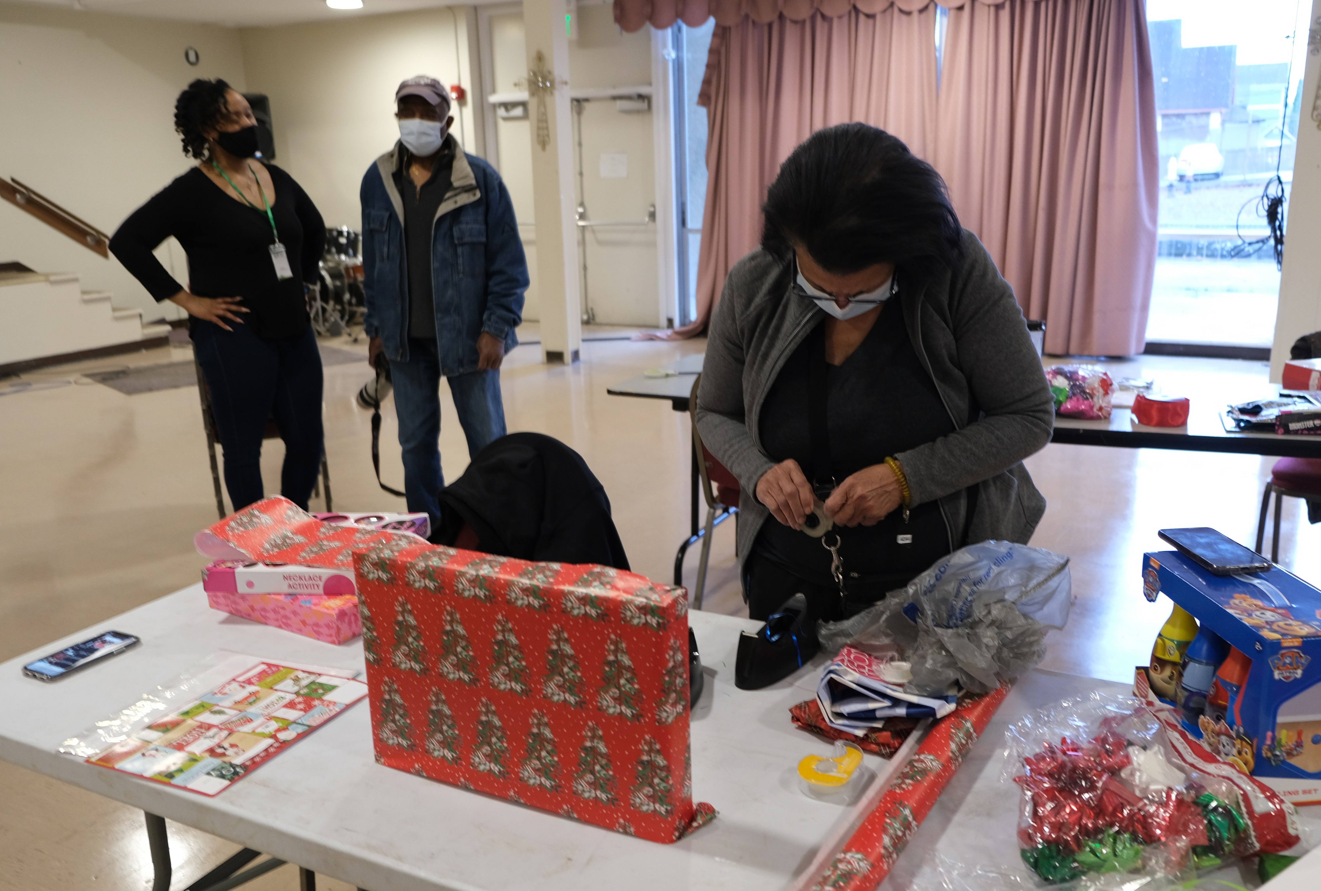 Volunteer from Seattle Credit Union wrapping holiday presents